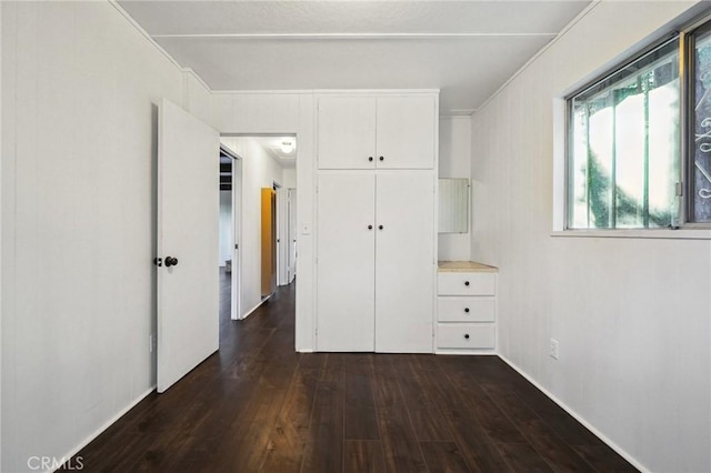 unfurnished bedroom with dark wood-type flooring