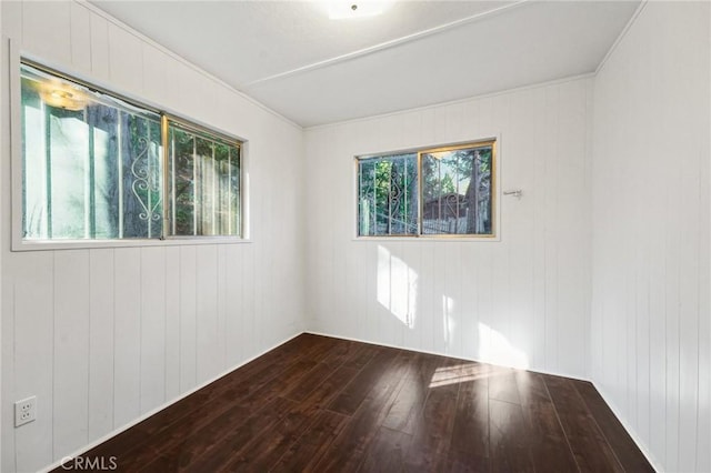 empty room with hardwood / wood-style flooring and wood walls