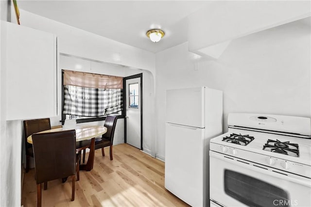 kitchen featuring white appliances, white cabinetry, and light wood-type flooring