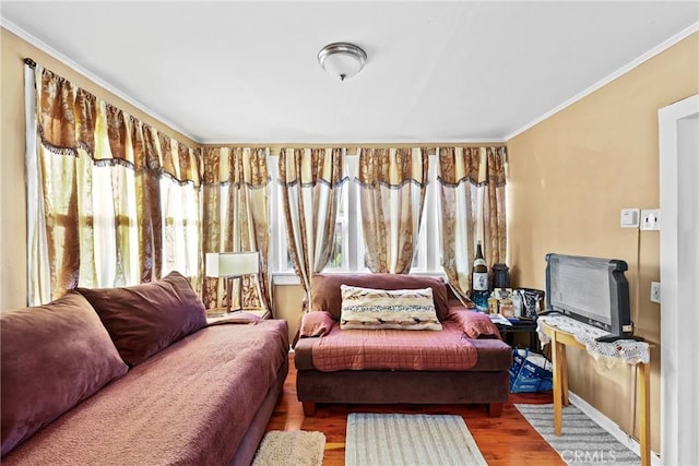 living area featuring hardwood / wood-style flooring, ornamental molding, and plenty of natural light