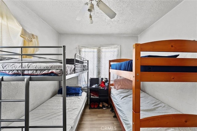 bedroom featuring a textured ceiling, ceiling fan, and hardwood / wood-style flooring