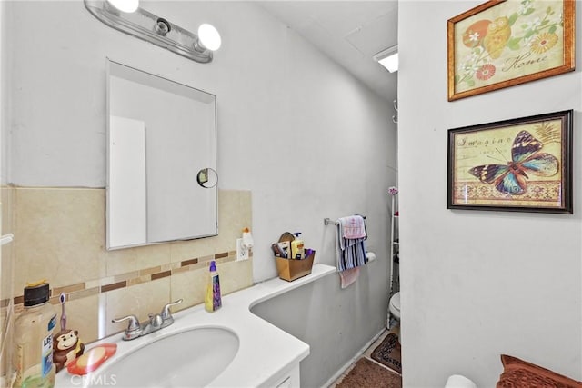 bathroom featuring toilet, vanity, and tasteful backsplash