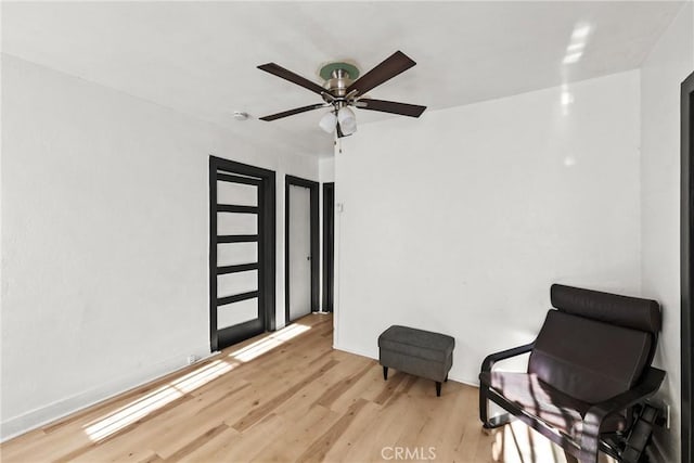 living area with ceiling fan and light hardwood / wood-style flooring