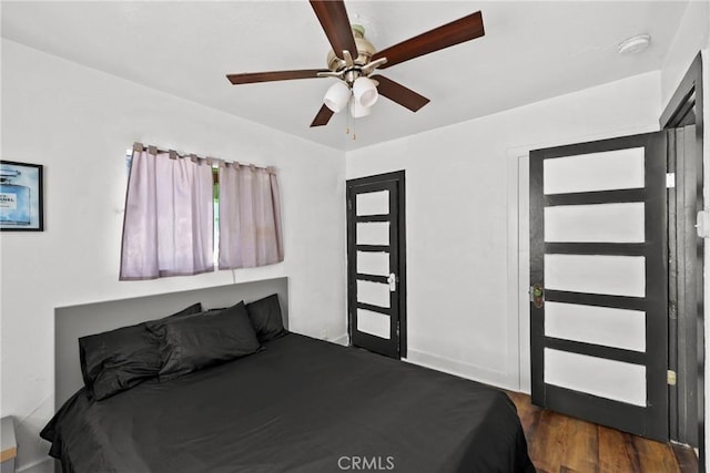 unfurnished bedroom with ceiling fan and dark hardwood / wood-style floors