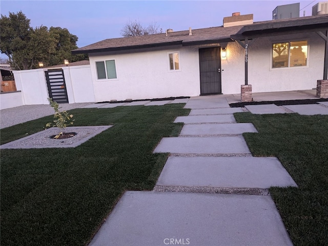 view of front facade with a yard and central AC