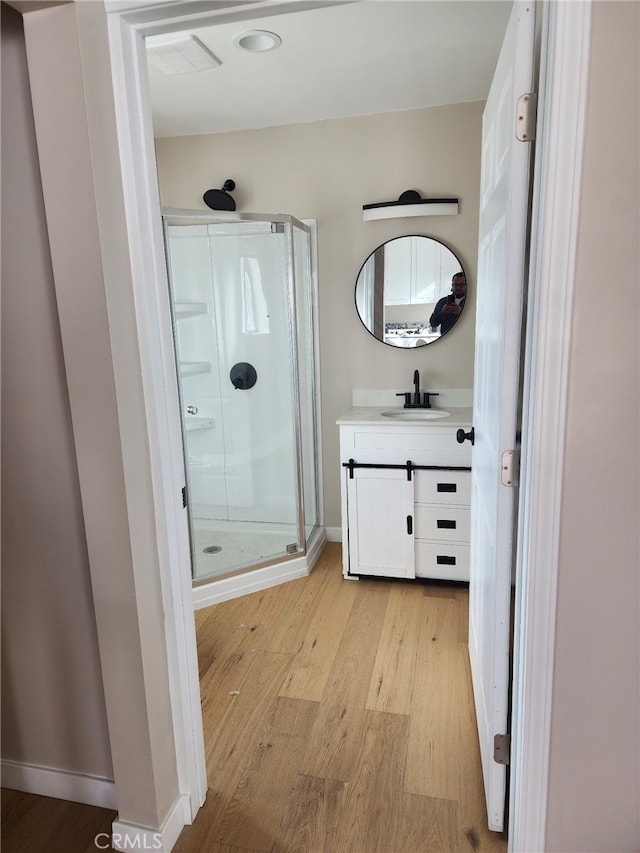 bathroom with vanity, wood-type flooring, and an enclosed shower