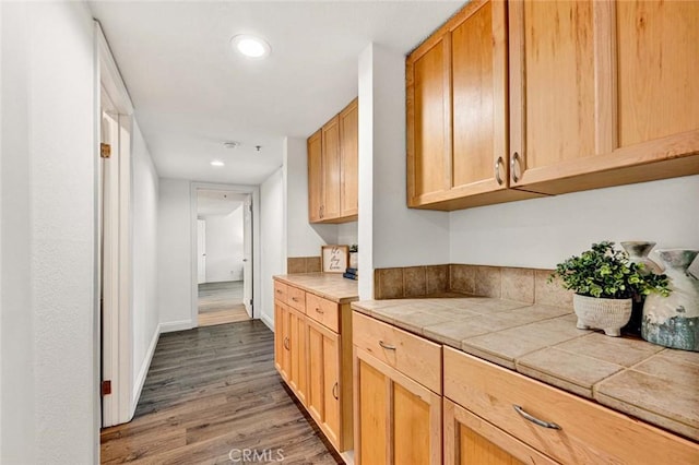 kitchen featuring tile counters, light brown cabinetry, and dark hardwood / wood-style flooring