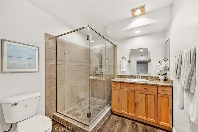 bathroom featuring walk in shower, vanity, and hardwood / wood-style floors