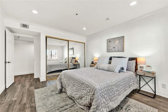 bedroom with a closet, ornamental molding, and dark hardwood / wood-style floors