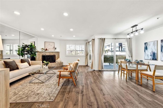 living room with wood-type flooring, a wealth of natural light, and crown molding