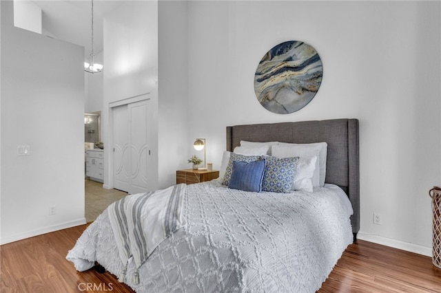 bedroom featuring wood-type flooring, connected bathroom, and a closet