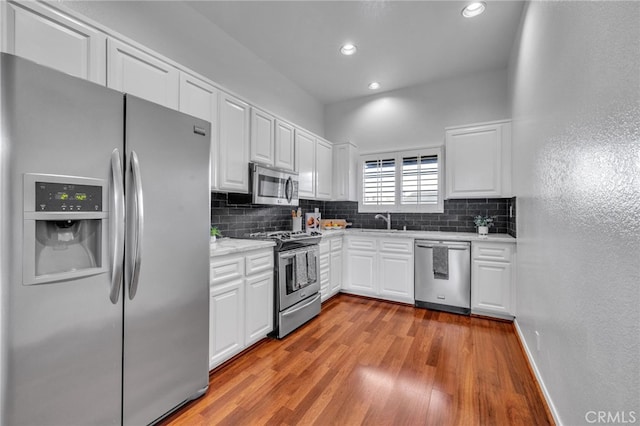 kitchen featuring white cabinetry, sink, light wood-type flooring, and appliances with stainless steel finishes