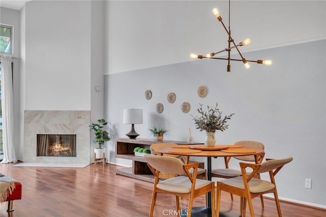 dining space with a notable chandelier, hardwood / wood-style flooring, and a high end fireplace