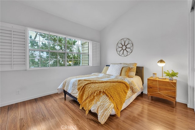 bedroom with vaulted ceiling and hardwood / wood-style floors