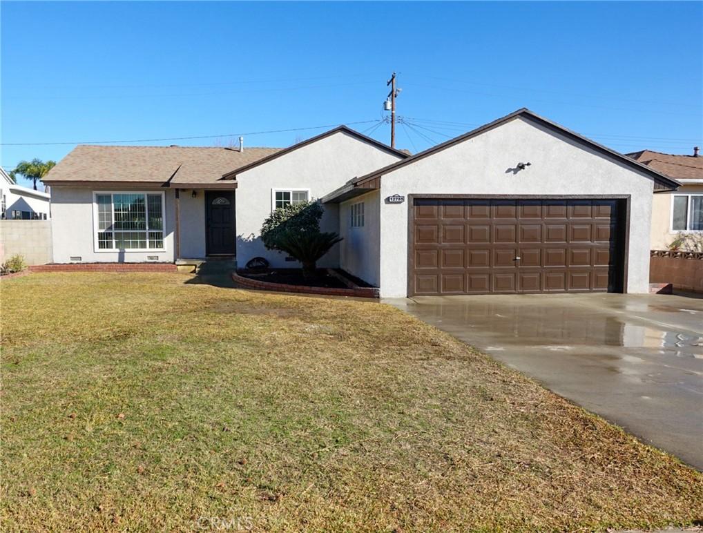 ranch-style house with a front yard and a garage