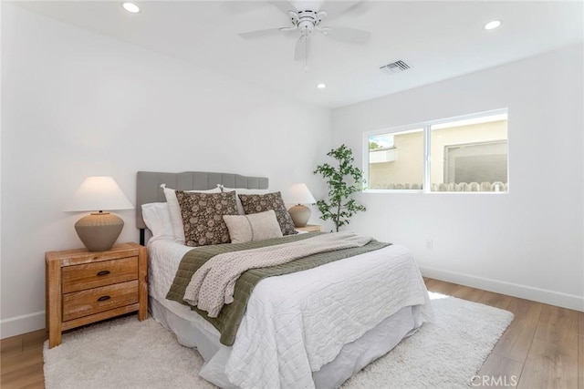 bedroom with visible vents, baseboards, and wood finished floors