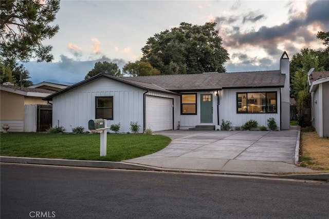 single story home with a garage, driveway, a lawn, a chimney, and fence