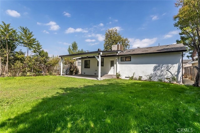 back of property featuring stucco siding, a lawn, a patio area, fence, and central AC