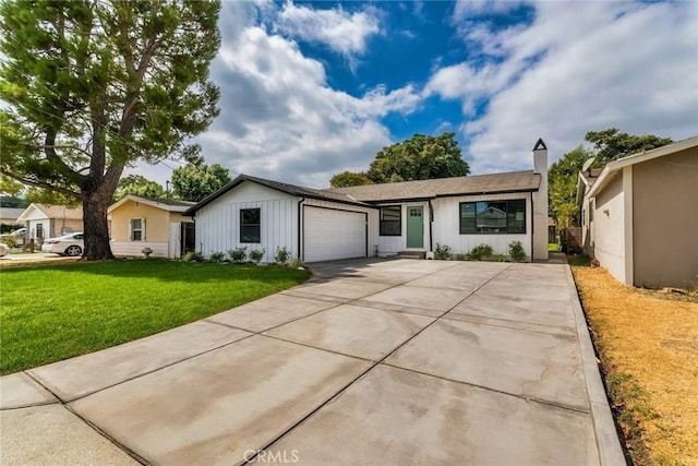 view of front of house with a garage, driveway, board and batten siding, and a front yard