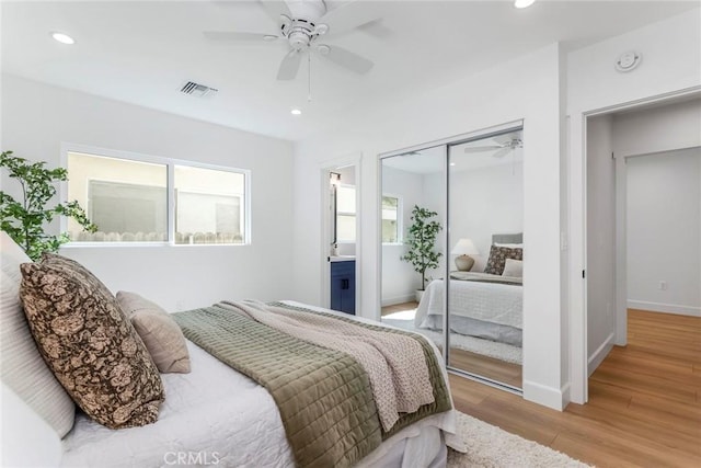 bedroom with recessed lighting, wood finished floors, visible vents, baseboards, and a closet