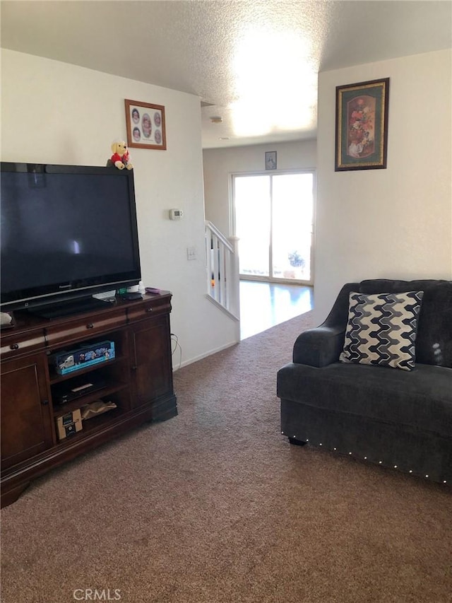 living room featuring a textured ceiling and carpet flooring