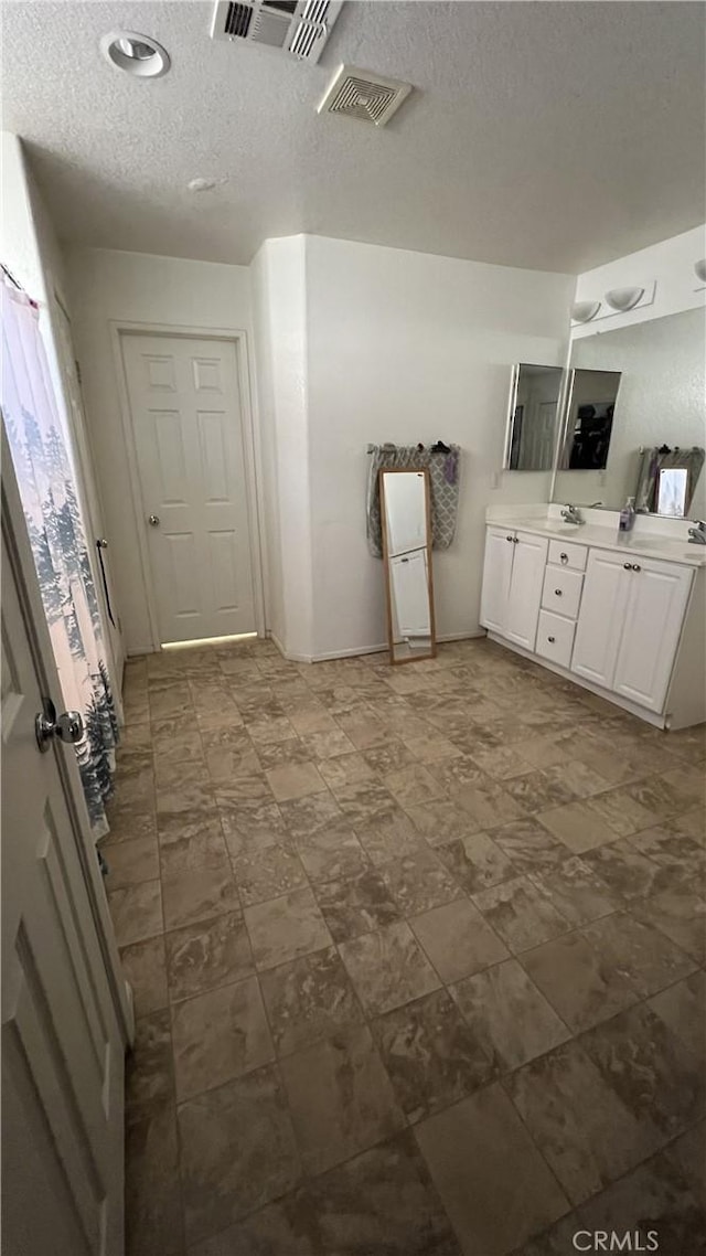 bathroom featuring a textured ceiling and vanity