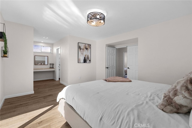 bedroom with baseboards and wood finished floors