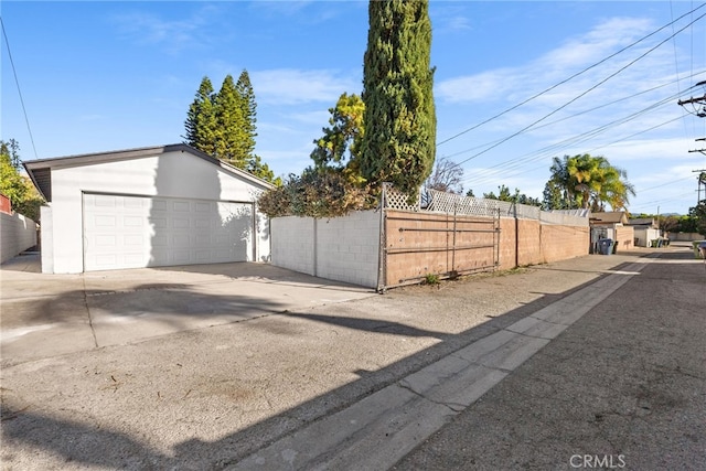 exterior space with a garage, fence, and an outbuilding