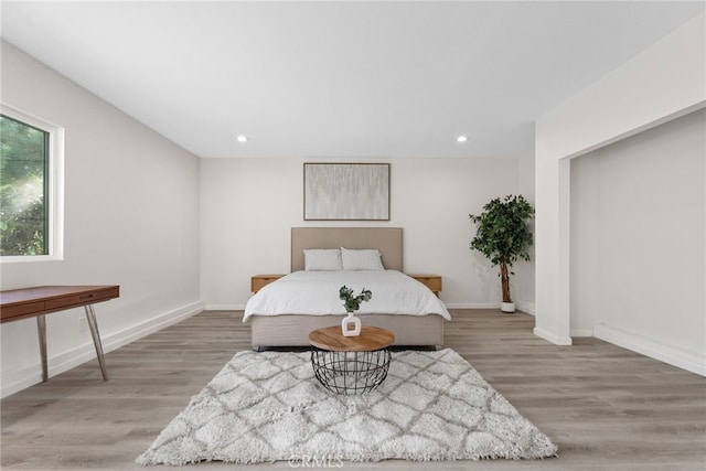 bedroom with recessed lighting, light wood-style flooring, and baseboards