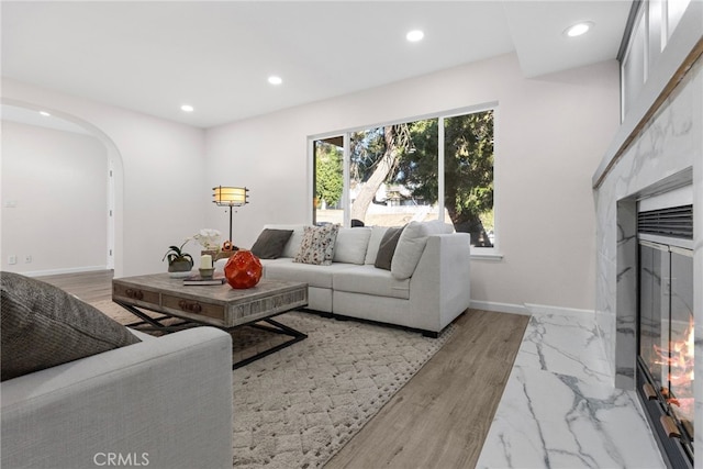 living area with arched walkways, baseboards, and recessed lighting