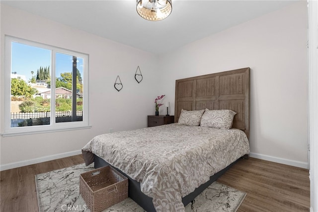 bedroom with baseboards and wood finished floors