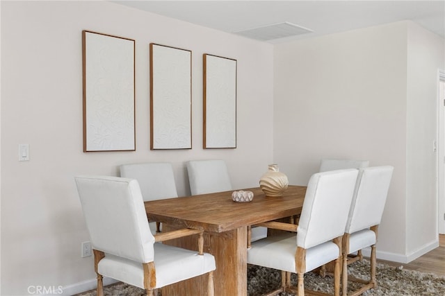 dining area with baseboards and wood finished floors