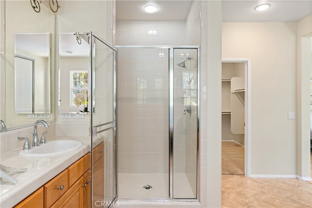 bathroom with tile patterned flooring, an enclosed shower, and vanity