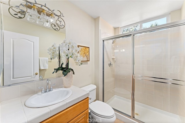 bathroom with toilet, an enclosed shower, and vanity