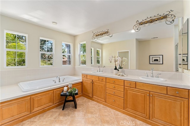 bathroom with a tub, a wealth of natural light, tile patterned floors, and vanity