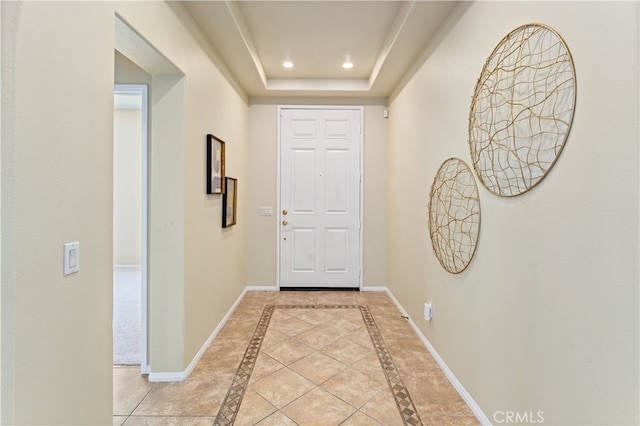 interior space with a raised ceiling and light tile patterned floors