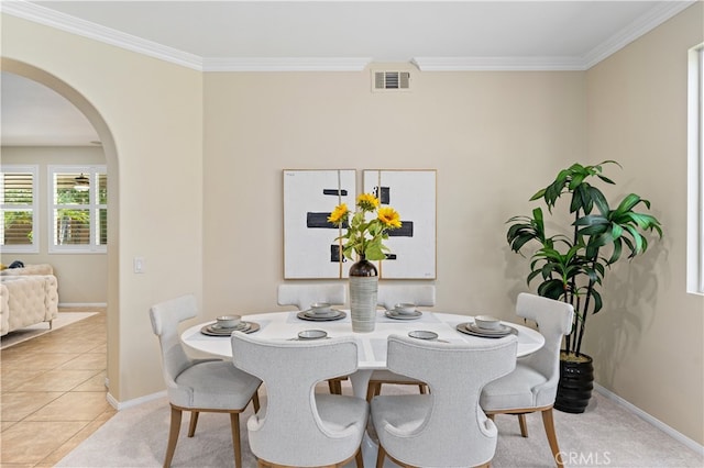 dining area featuring crown molding and light tile patterned floors