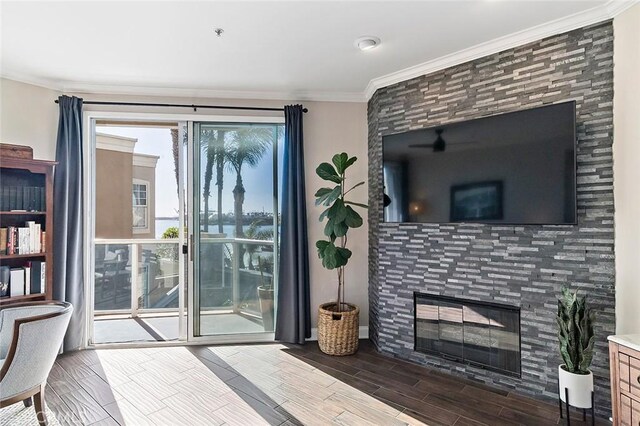 living room with crown molding and a tiled fireplace