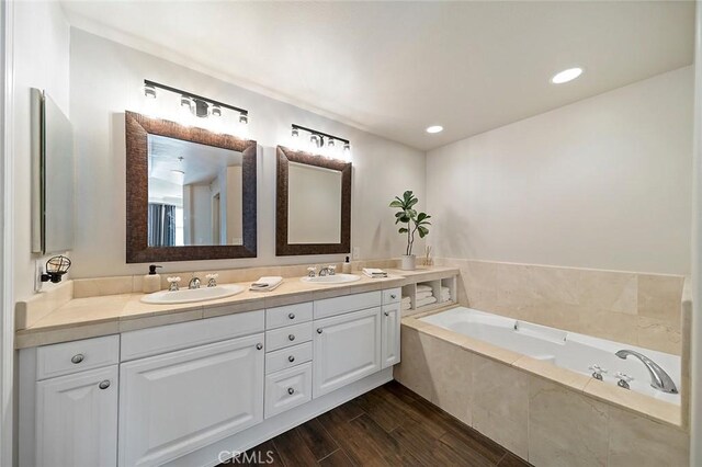 bathroom with a relaxing tiled tub and vanity