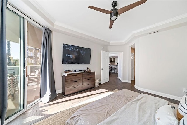 bedroom with ceiling fan, dark wood-type flooring, crown molding, and a raised ceiling