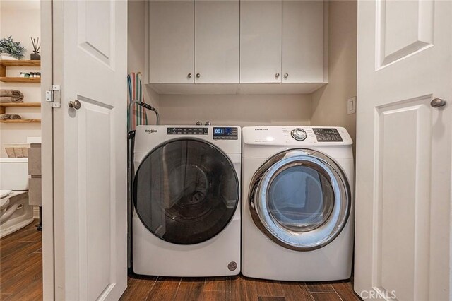 laundry room featuring washing machine and dryer and cabinets