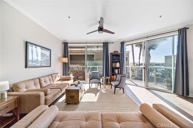 living room featuring ceiling fan, light wood-type flooring, a wealth of natural light, and floor to ceiling windows