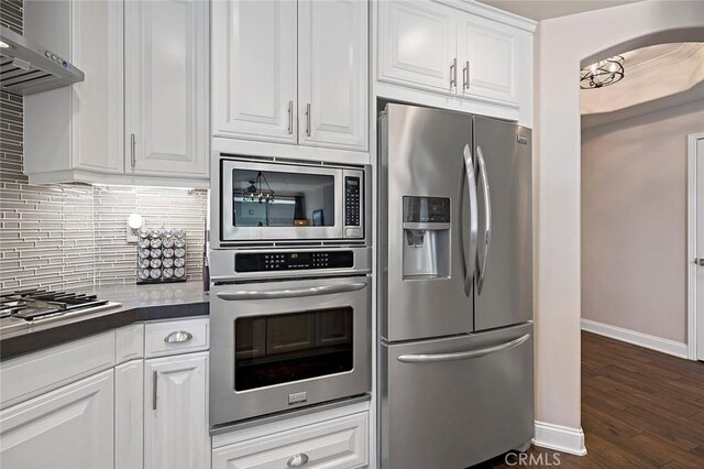 kitchen with white cabinets, backsplash, appliances with stainless steel finishes, and ventilation hood