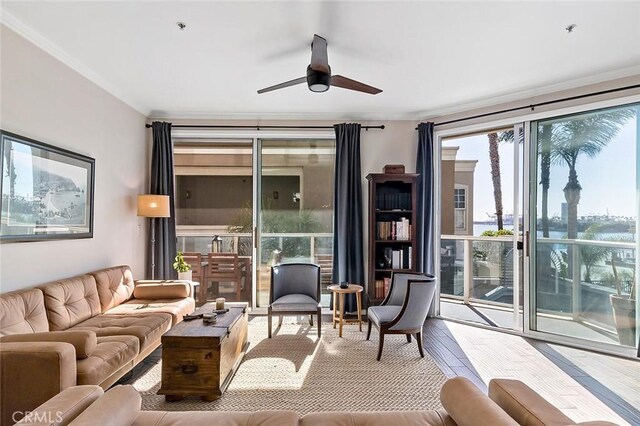 living room featuring ceiling fan, crown molding, hardwood / wood-style flooring, and expansive windows