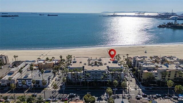 drone / aerial view featuring a water view and a beach view