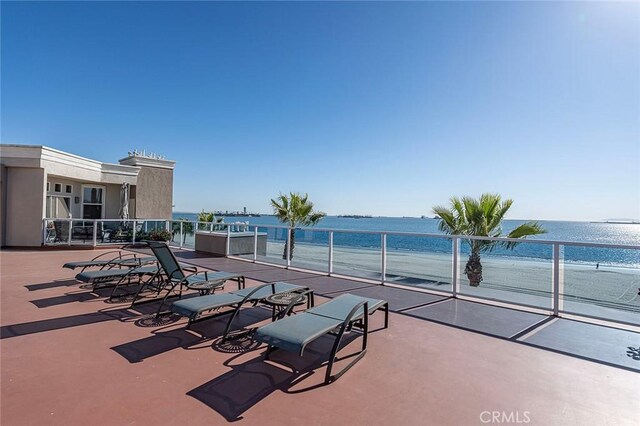 view of patio featuring a water view and a beach view