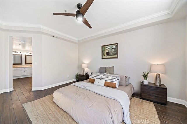 bedroom with dark hardwood / wood-style flooring, a raised ceiling, ceiling fan, ensuite bathroom, and crown molding