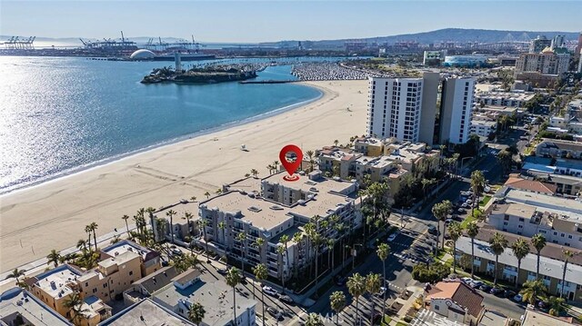 birds eye view of property with a water view and a beach view