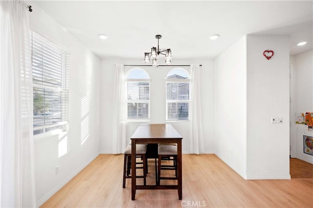 dining room with plenty of natural light, light hardwood / wood-style flooring, and a chandelier