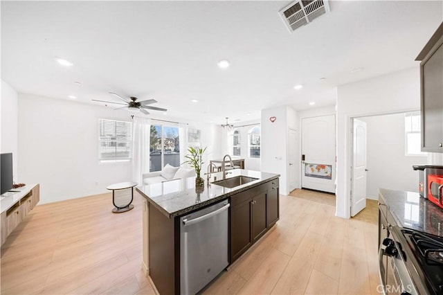 kitchen with appliances with stainless steel finishes, light hardwood / wood-style floors, a center island with sink, and sink